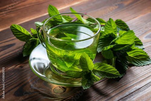 hot cup of tea with mint on wooden table