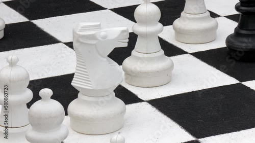 Close-up of exterior giant chessboard and pawns