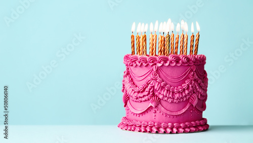 Elaborate birthday cake with vintage style buttercream icing and gold birthday candles photo