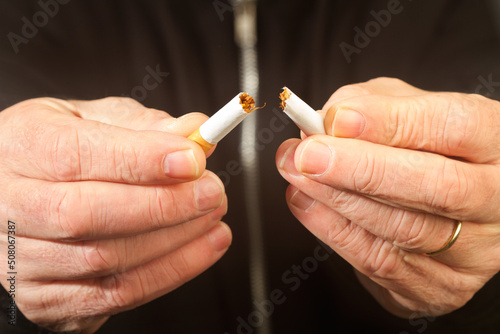 Manos de hombre rompiendo un cigarrillo para una buena salud. Vista de frente y de cerca. Concepto: Stop fumar, vida sana