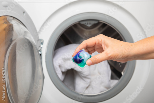 Canvastavla Woman putting laundry detergent capsule into washing machine indoors, closeup