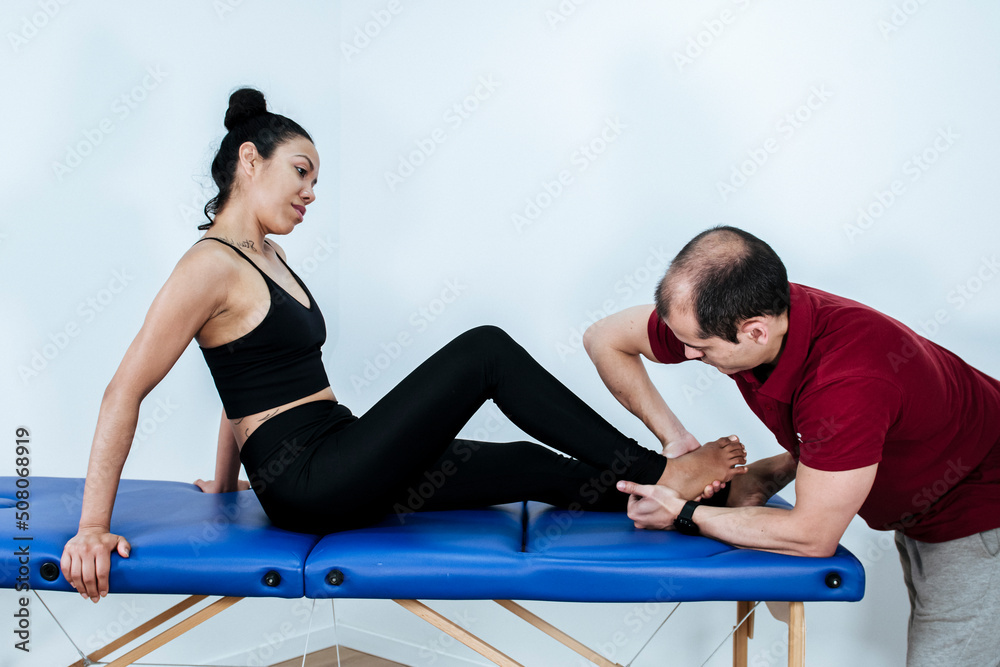 Therapist mobilizing the ankles of a young woman Therapist mobilizing the ankles of a young woman