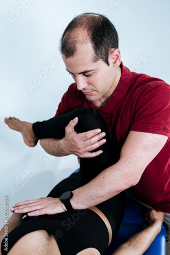 Therapist mobilizing the leg and hip of a young woman