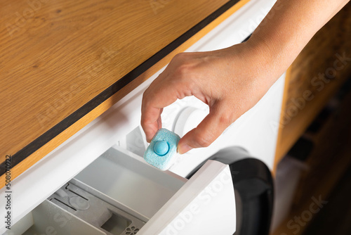 Capsule for softening water and preventing limescale in the washing machine. close-up. Washing clothes. The concept of washing and cleanliness