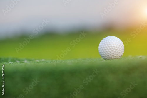 Golf ball on Green field golf course in morning time with soft sunlight.