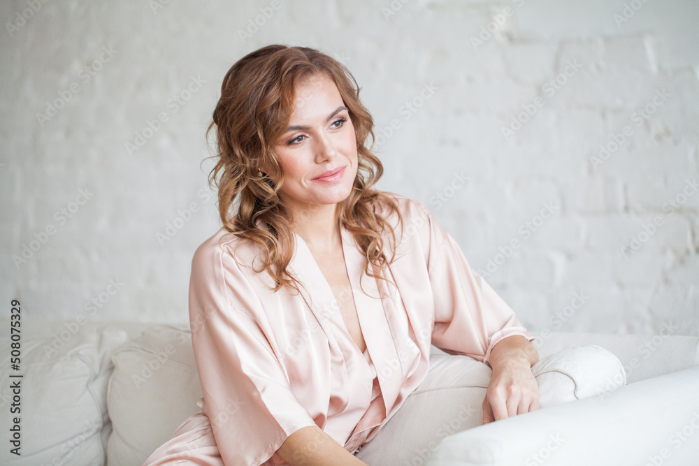 Young beautiful woman sitting on couch at home Young beautiful woman sitting on couch at home