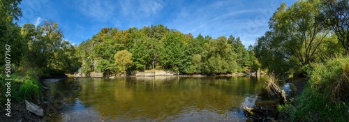 panorama river in valley with forest and rocks on the shore