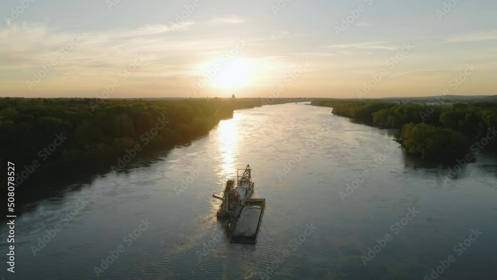 Aerial view towards a river sand dredging ship, sunny evening in Missouri, USA - tilt, drone shot Aerial view towards a river sand dredging ship, sunny evening in Missouri, USA - tilt, drone shot