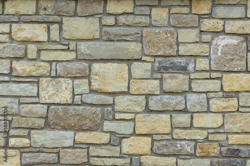 Solid yellow and beige stone wall. Stone background. Solid yellow and beige stone wall. Stone background.
