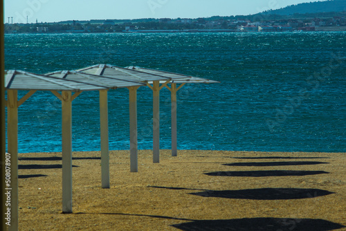 beach umbrellas lined up on the seashore on a sandy beach