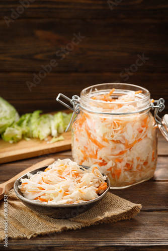Fotografie Fresh pickled cabbage - sauerkraut with carrot on a wooden table.