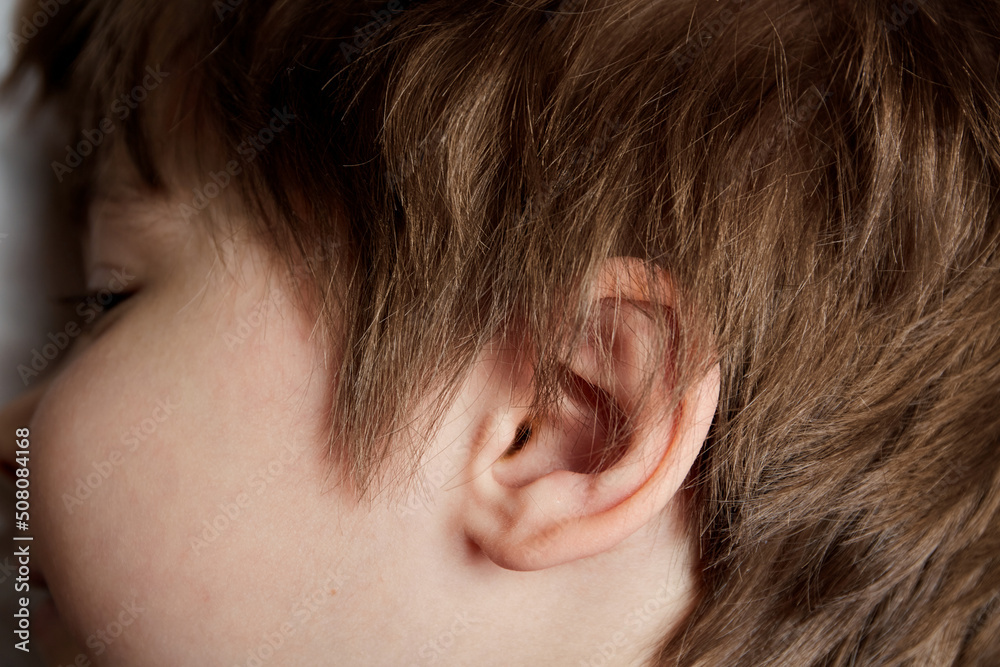 Child ear close-up. Copy space. Deafness. Concept of medical exam and treatment by an otolaryngologist. Hearing check and recovery. Proper care and cleaning of ears. Audio perception of information Child ear close-up. Copy space. Deafness. Concept of medical exam and treatment by an otolaryngologist. Hearing check and recovery. Proper care and cleaning of ears. Audio perception of information