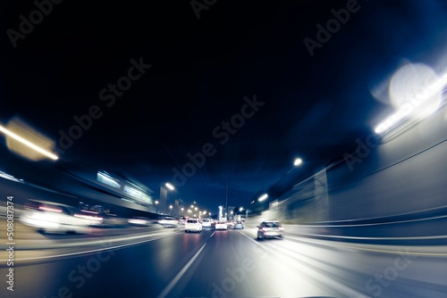 CITY STREET AT NIGHT WITH MOTION BLURRED LIGHTS OF FAST MOVING CARS, MODERN CITYSCAPE, RUSH ON THE STREET. High quality photo © Avi