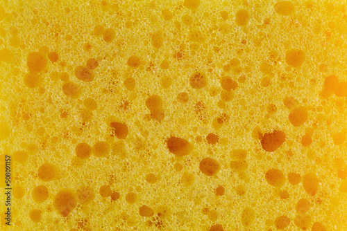 Dishwashing sponge texture close up photo. Yellow sponge pattern macro photography.
