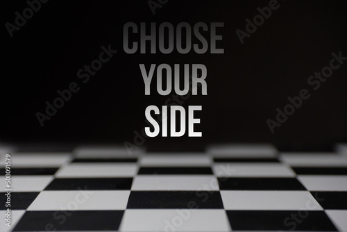 The inscription choose your side over the chessboard. The concept of confrontation and war.