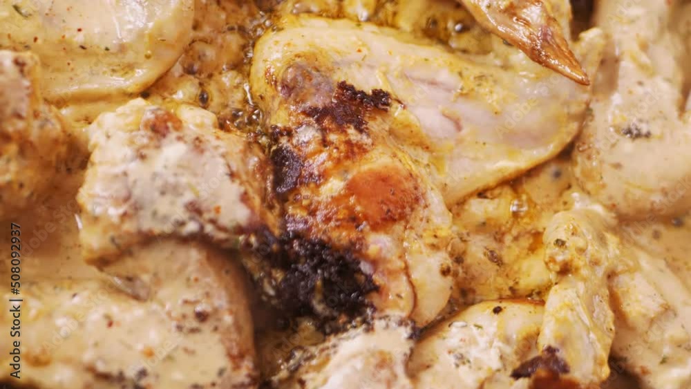 Fried chicken wings in a frying pan poured with sauce are turned over with a spatula Fried chicken wings in a frying pan poured with sauce are turned over with a spatula