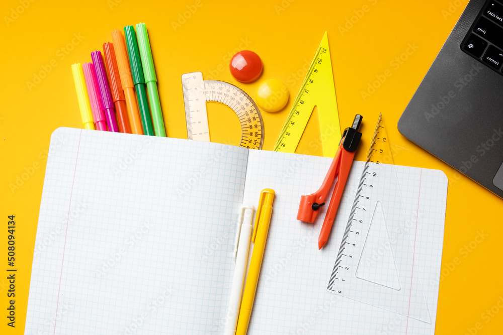 Back to school background. Empty mockup notepad and school supplies. Top view.