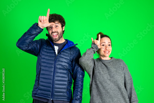 Young beautiful couple with lol message pointing, hand sign