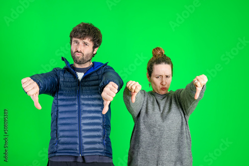 Photo of sad and disappointed man and woman with thumbs down