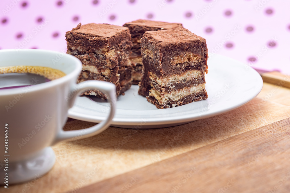 Uma xícara com café e palha italiana sobre madeira, sobre superfície cor-de-rosa. Uma xícara com café e palha italiana sobre madeira, sobre superfície cor-de-rosa.