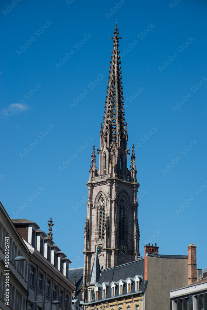 closeup of tower bell of the St Etienne protestant temple on blue cloudy sky background in Mulhouse - France