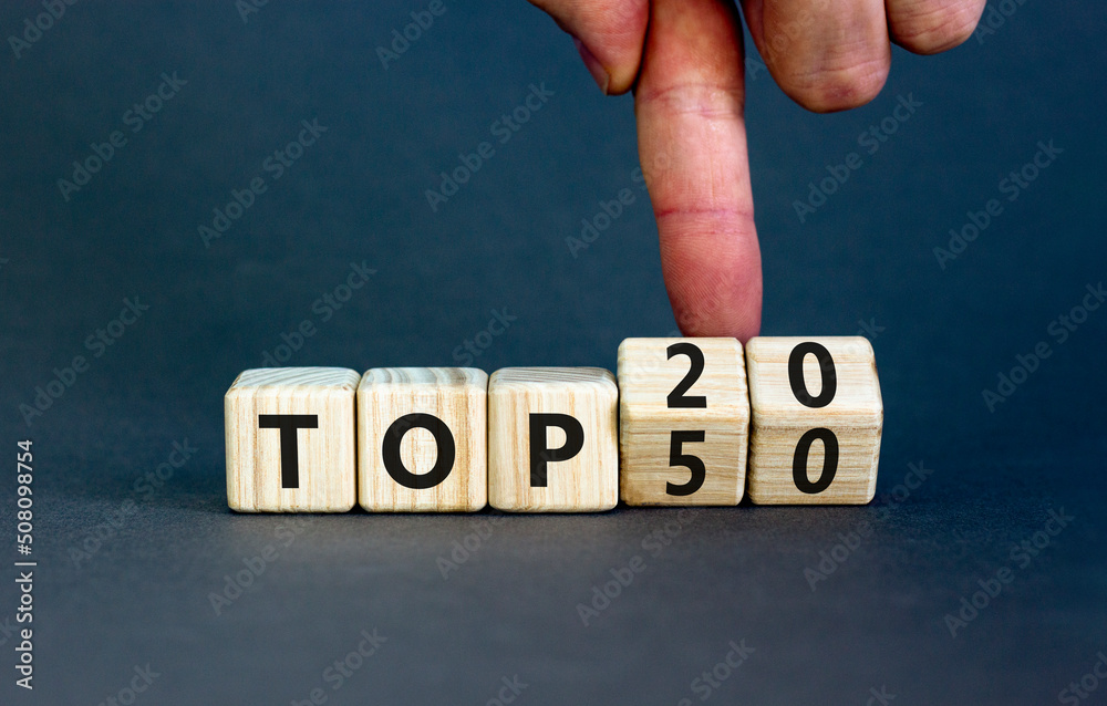 From Top 50 to 20 symbol. Businessman turns wooden cubes and changes