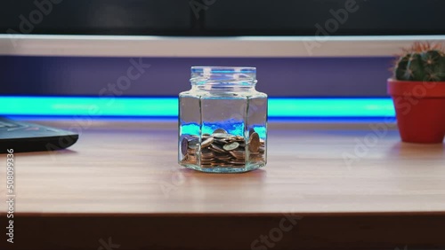Timelapse - Savings slowly filling up the jar as time passes while camera orbits around the jar