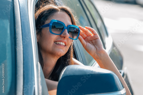 smiling woman in car window © carballo