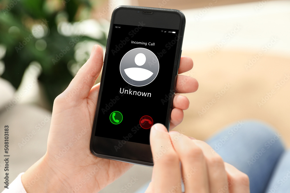 Woman declining incoming call from unknown caller indoors, closeup. Be careful - fraud Woman declining incoming call from unknown caller indoors, closeup. Be careful - fraud