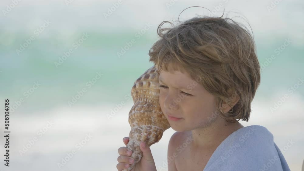 portrait of a blond child with blue eyes hearing shell song, blue sea, innocence and purity
