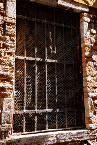 Ancient metal bars on the window from the Middle Ages. Powerful grids. Defense