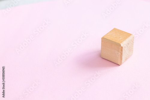 wooden geometric shapes cube isolated on a pink