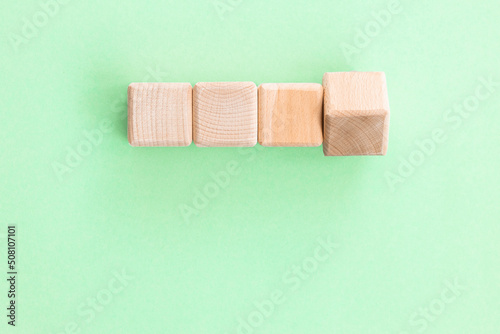 Wooden geometric shapes cubes isolated on a green background