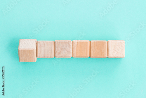 Wooden geometric shapes cubes isolated on a blue background