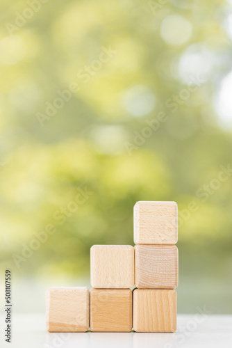 Wooden cubes from natural wood on a green summer background. Copy, empty space for text