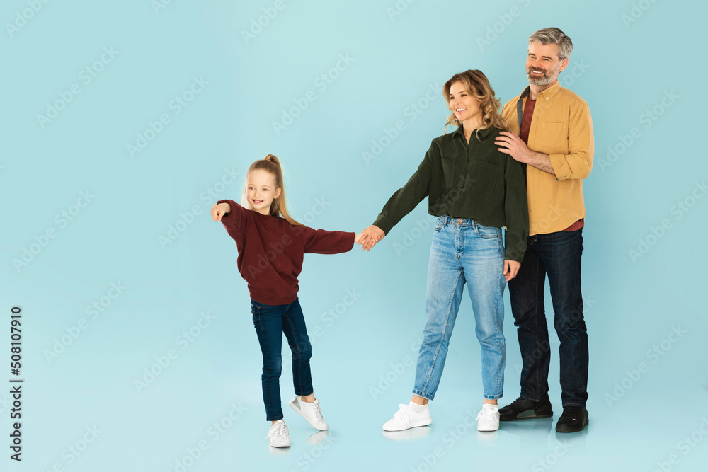 Daughter Holding Hands With Parents Pointing Finger On Blue Background