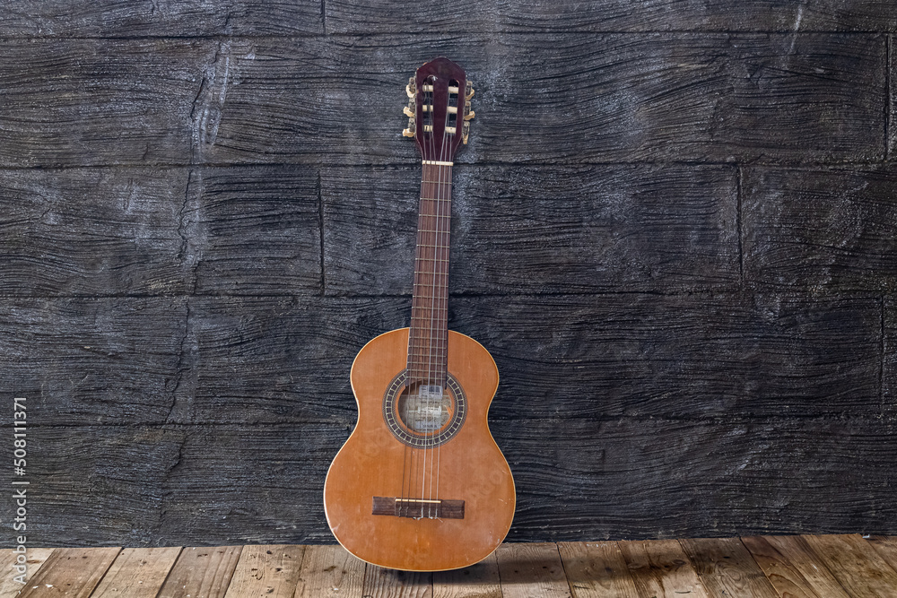 Naklejka premium Acoustic guitar in a rustic wooden setting