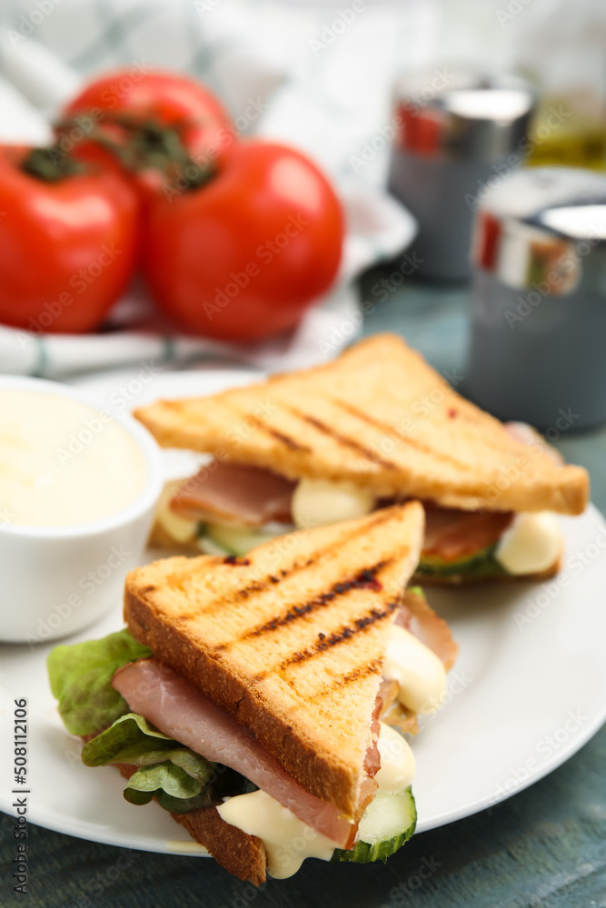 Delicious sandwiches with vegetables, ham and mayonnaise on plate, closeup Delicious sandwiches with vegetables, ham and mayonnaise on plate, closeup