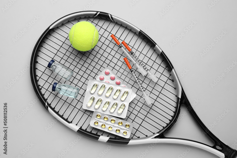 Tennis racket with ball and drugs on light grey background, top view. Doping concept