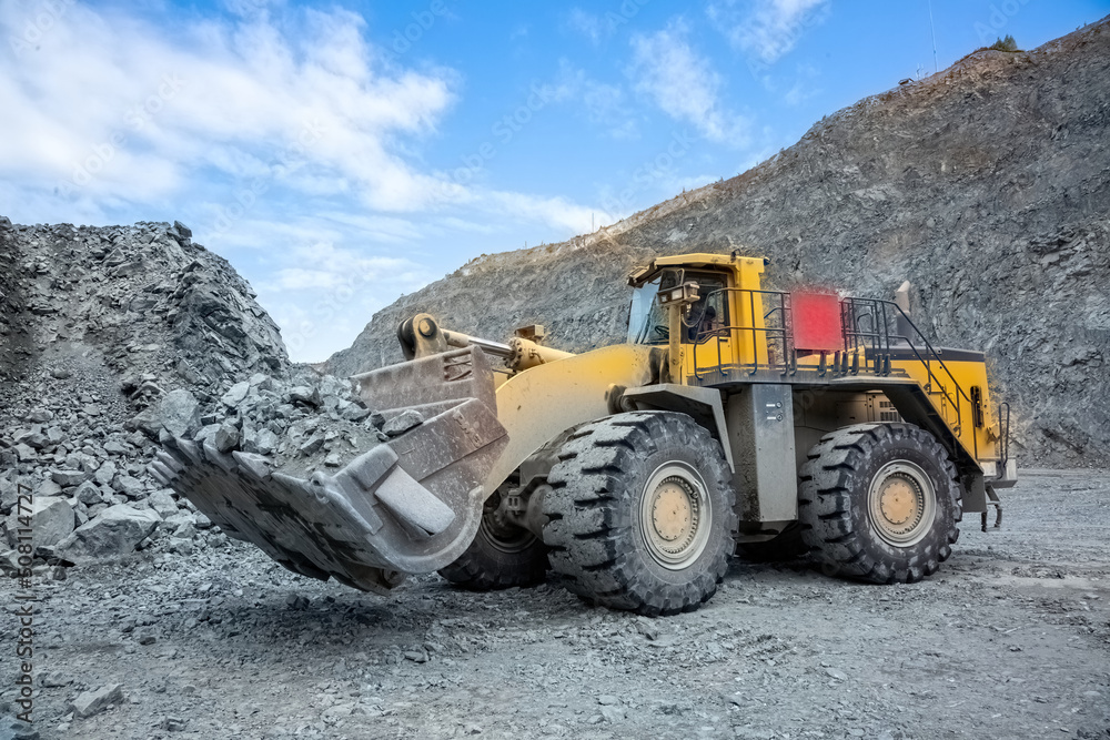 Transportation of copper ore rocks by dump trucks. Large quarry yellow truck. The mining truck drives through the quarry. Transportation of copper ore rocks by dump trucks. Large quarry yellow truck. The mining truck drives through the quarry.