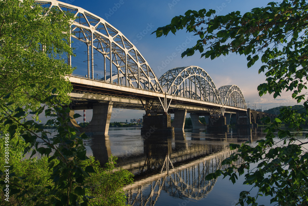 New Darnytskyi Bridge across Dnipro river in Kyiv, Ukraine on calm spring day.