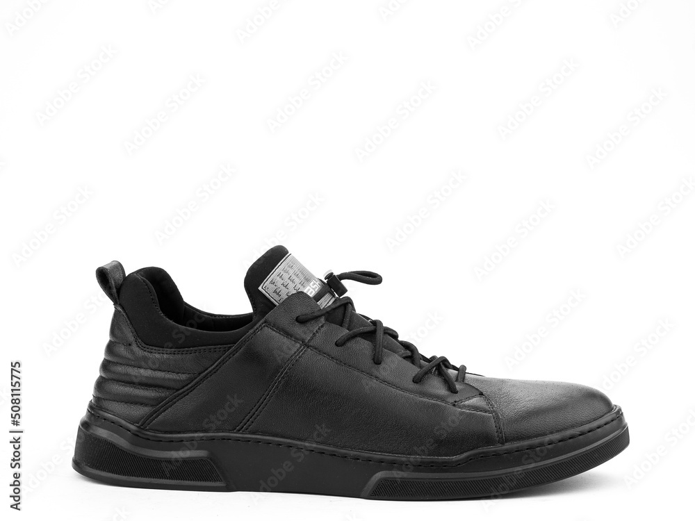 Black leather classic sneakers with laces. Casual men's style. Black rubber soles. Isolated close-up on white background. Right side view.