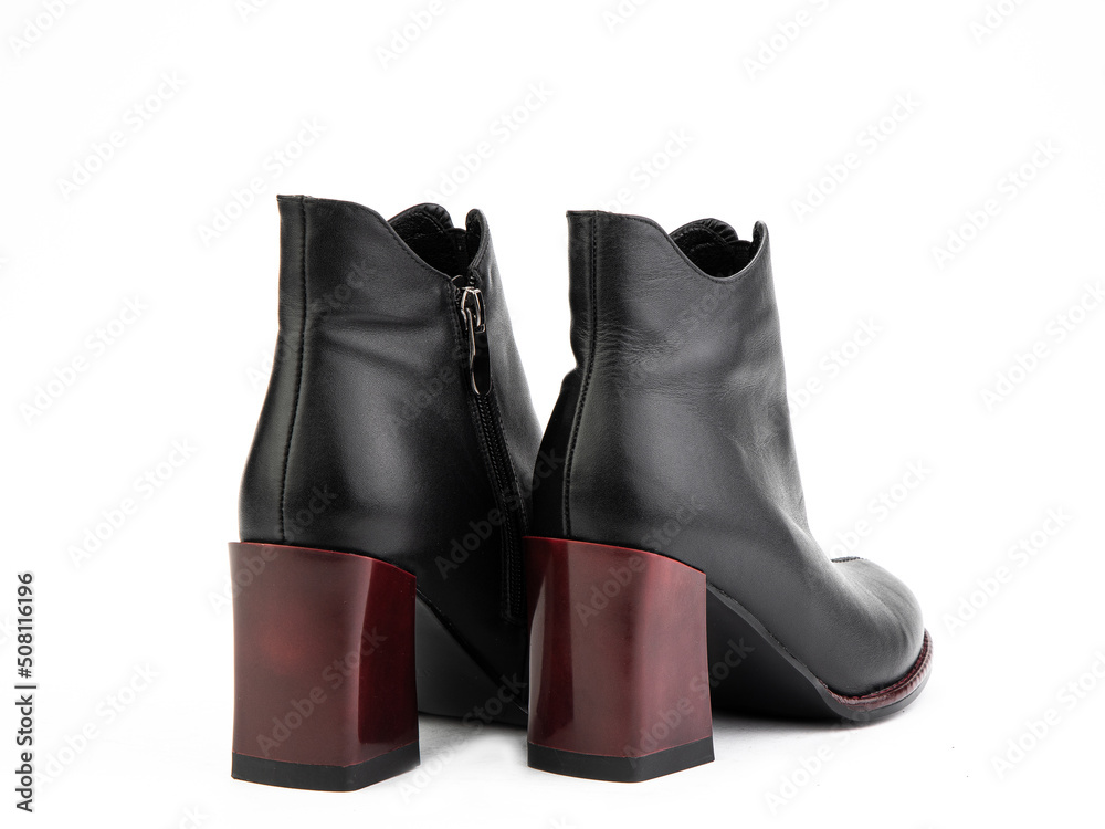 Women's autumn ankle leather boots with black zip and red average heels, isolated white background. Back side view. Fashion shoes. shoe shop concept.