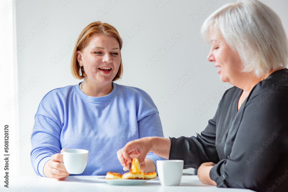 Ukrainian mother and daughter have a discussion during breakfast in the kitchen Ukrainian mother and daughter have a discussion during breakfast in the kitchen