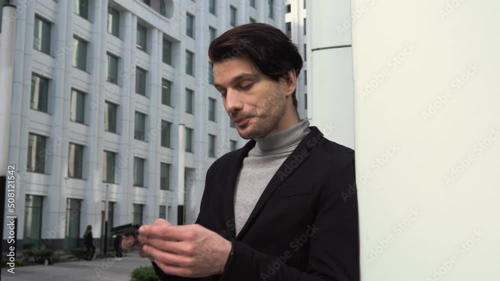 Young caucasian man using cell phone. Texting and feeling happy. Corporate career opportunities concept Young caucasian man using cell phone. Texting and feeling happy. Corporate career opportunities concept