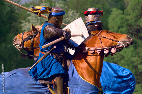Knightly tournament on horseback. Two knights attack each other with spears at a gallop. One on one duel.