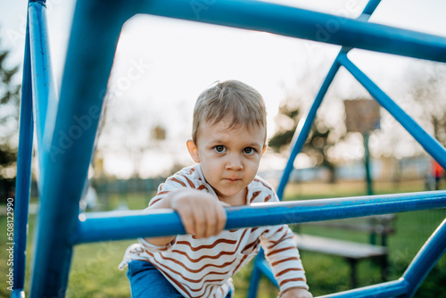 A little boy playing on outdoor playground.