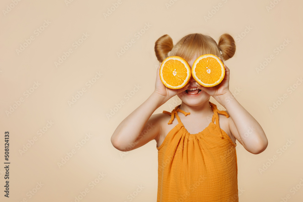 Girl holding oranges in front of her face