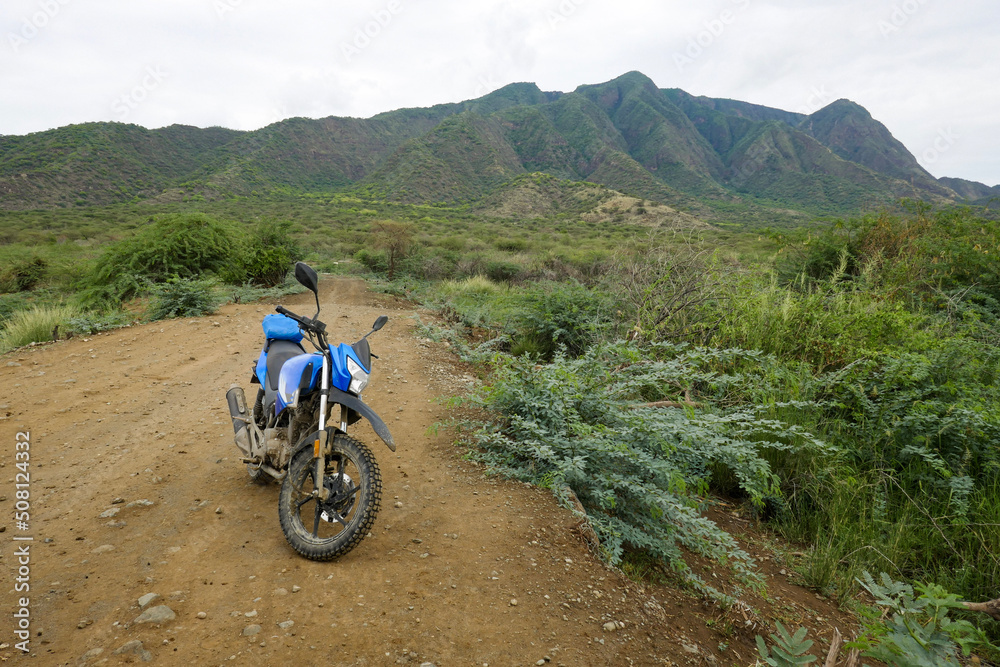 A motorcycle in the wild against the background of Shompole Hills, Kajiado, Kenya