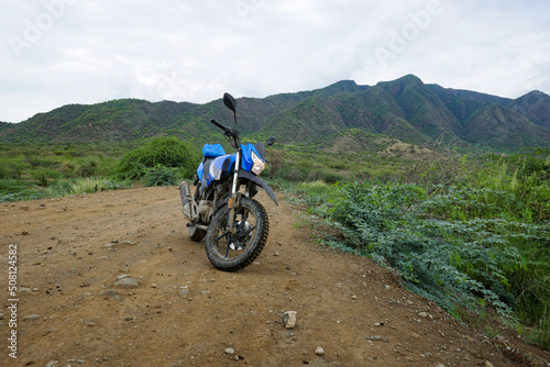 Fototapeta Naklejka Na Ścianę i Meble -  A motorcycle in the wild against the background of Shompole Hills, Kajiado, Kenya